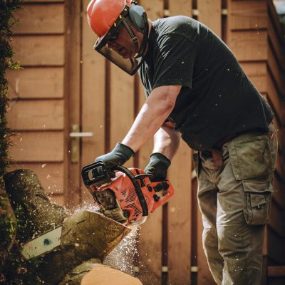 pexels photo 8489862 8489862 Worker using a chainsaw to cut wood, wearing safety gear in an outdoor setting.
