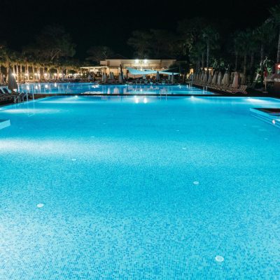 pexels photo 9119784 9119784 A luxurious resort swimming pool illuminated at night, offering a serene and elegant ambiance.